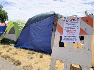 caption: A homeless encampment was forced off of public property in Burien in May.