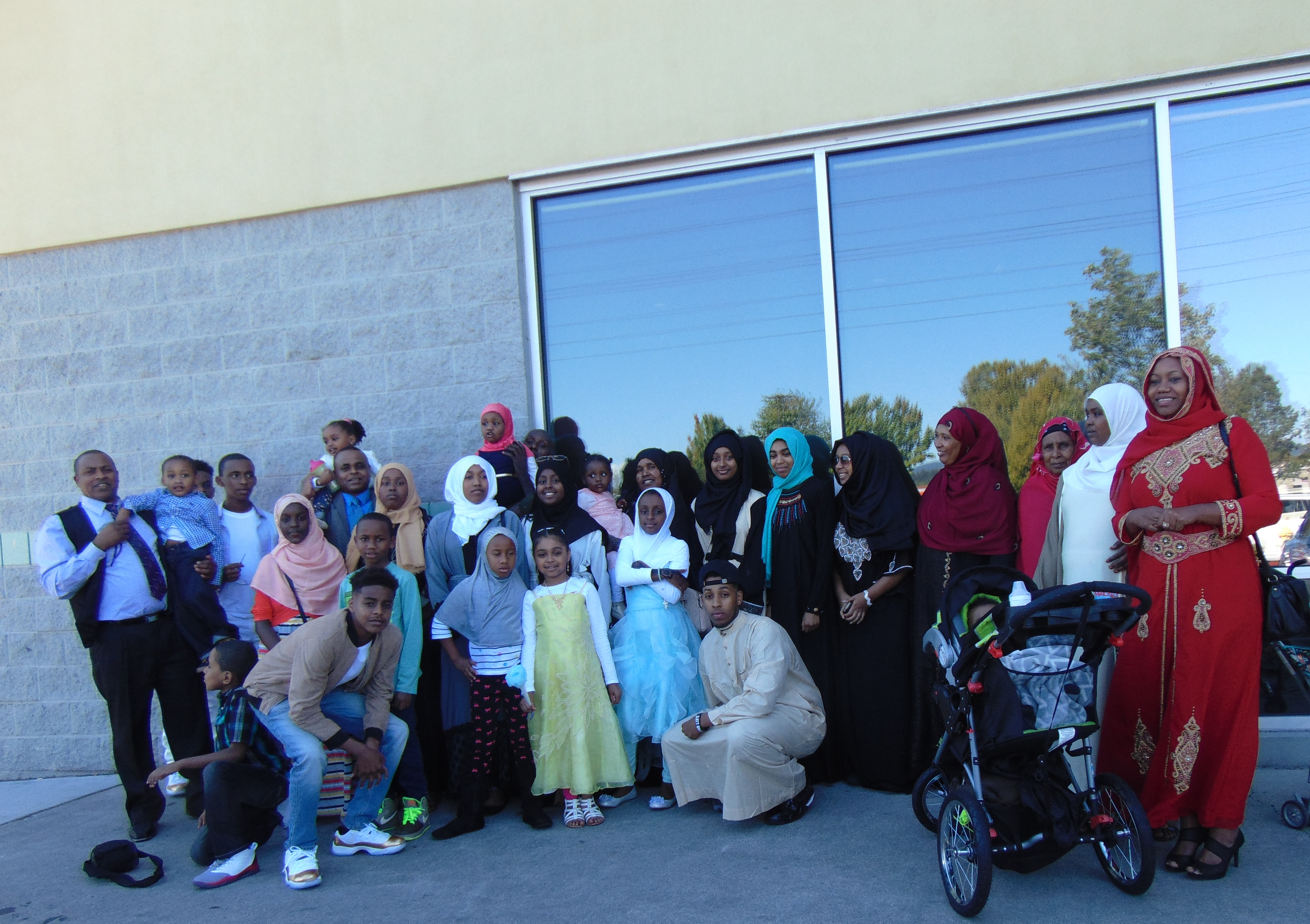 caption: Omar Ali with his family. Omar is standing fourth form the left holding his daughter.