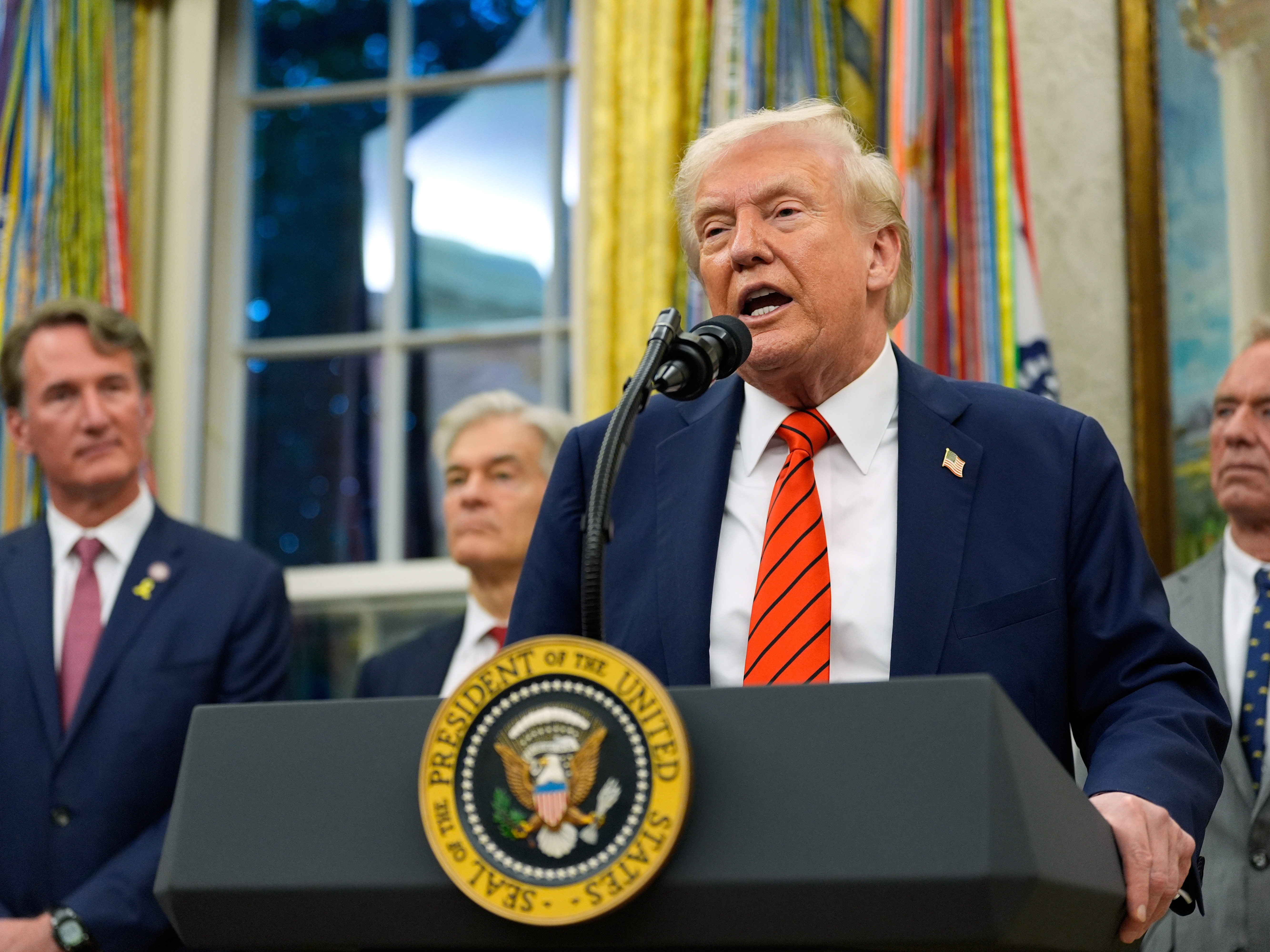 caption: President Donald Trump speaks in the Oval Office of the White House, Friday, Oct. 10, 2025, in Washington, as Virginia Gov. Glenn Youngkin, Centers for Medicare &amp; Medicaid Services administrator Dr. Mehmet Oz and Health and Human Services Secretary Robert F. Kennedy Jr., listen.
