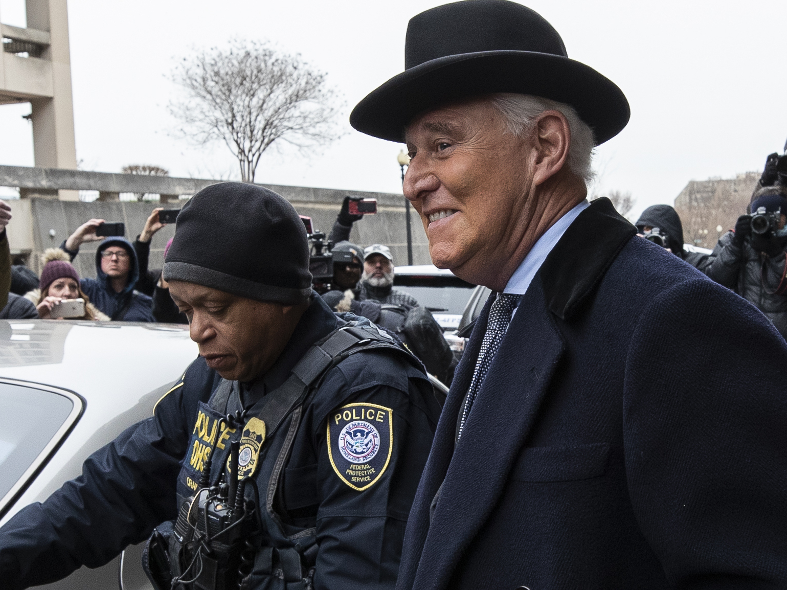 caption: Roger Stone, center, departs federal court in Washington on Thursday.