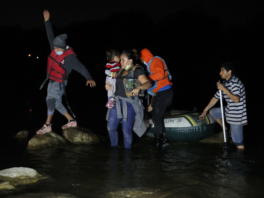 caption: A group of migrants from El Salvador arrives in Roma, Texas, after crossing the Rio Grande on March 30, 2021 in Roma, Texas.