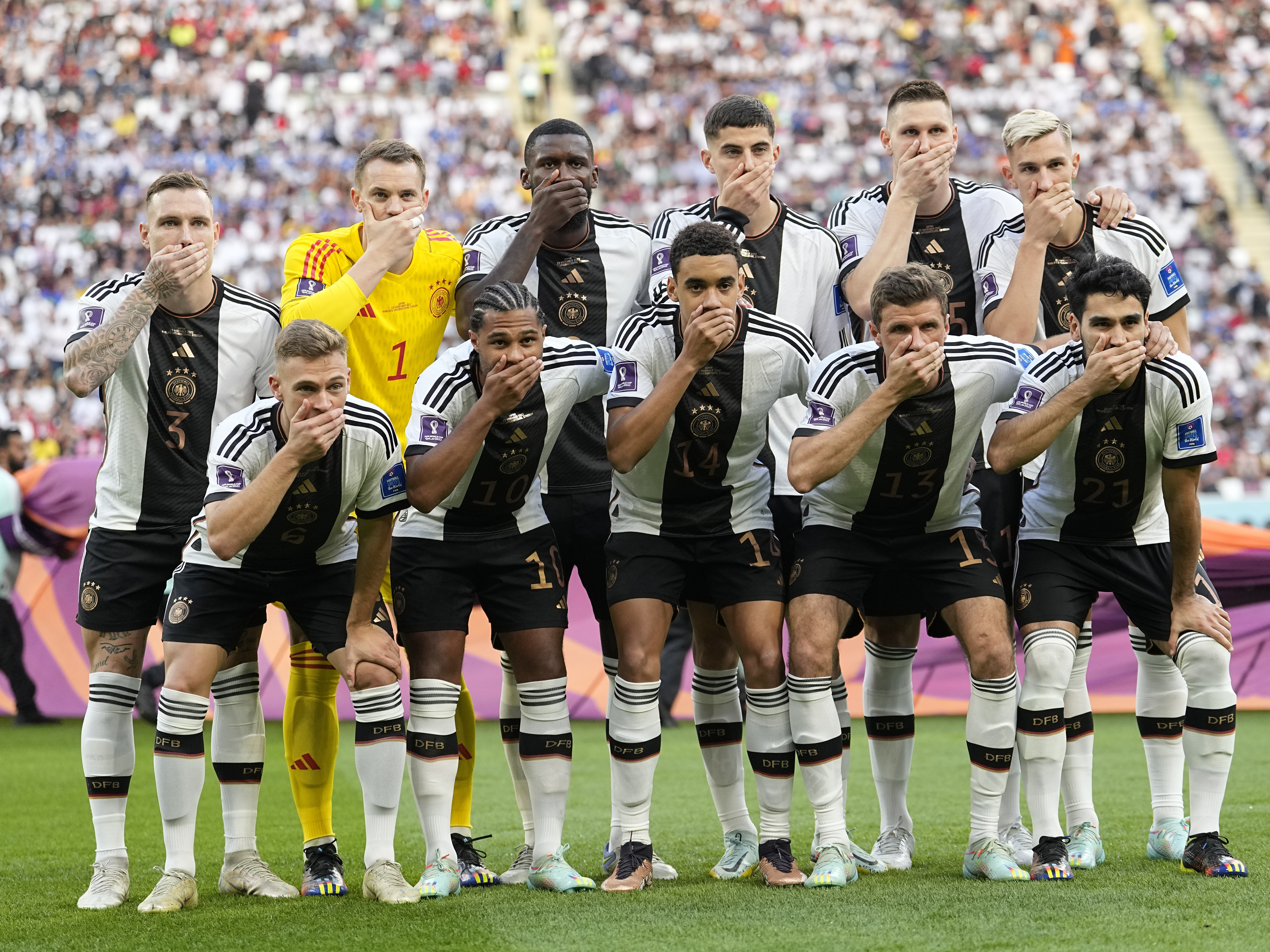 caption: Players from Germany pose for the team photo as they cover their mouth during the World Cup group E soccer match between Germany and Japan on Wednesday.