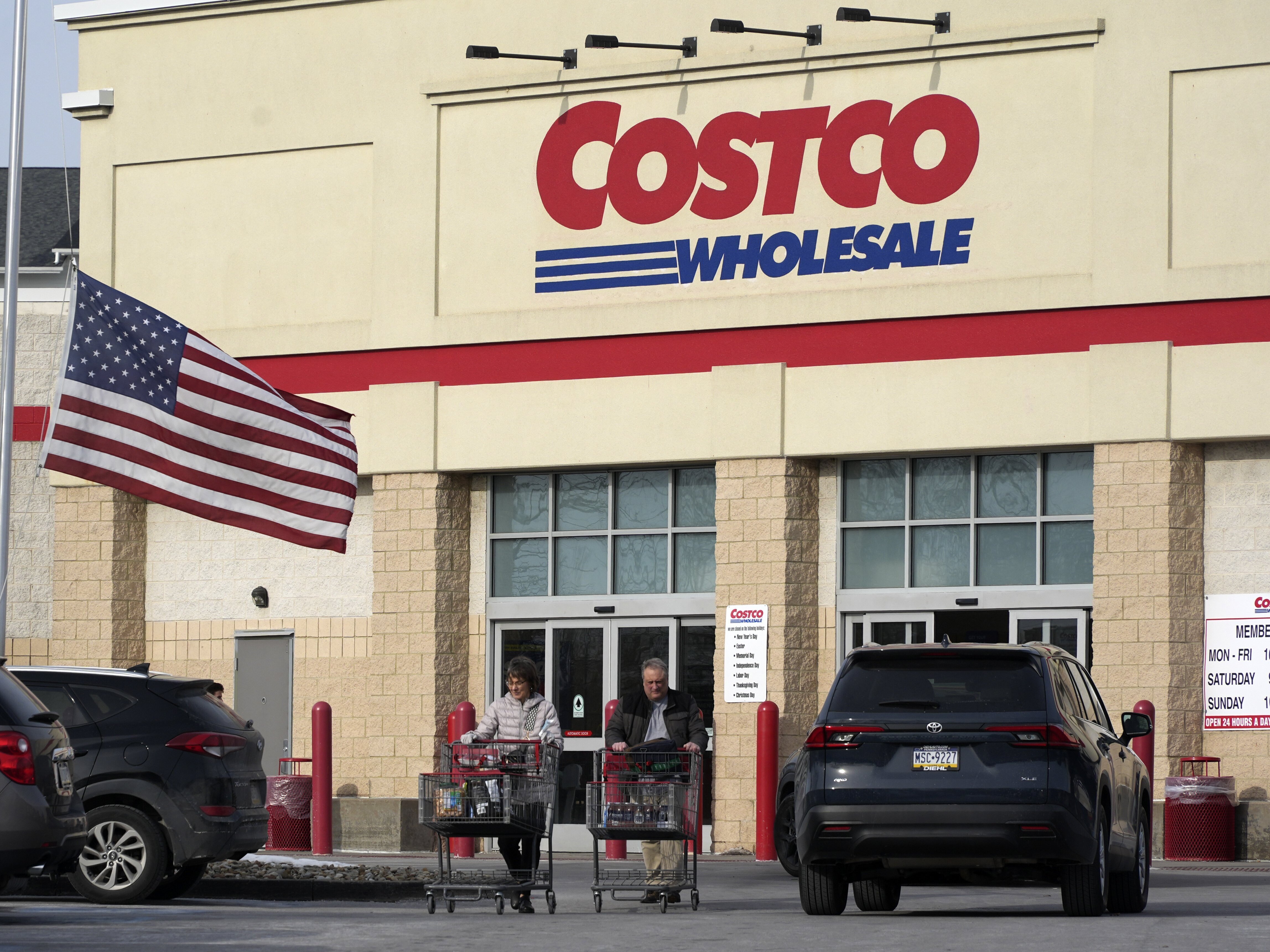 caption: Shoppers exit a Costco Warehouse in Cranberry, Pa., on Jan. 28.