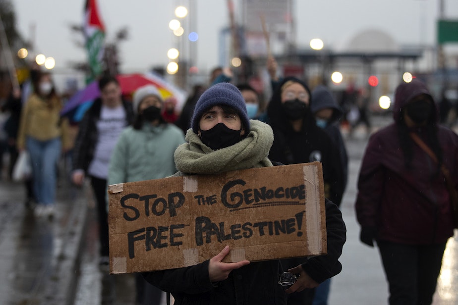 caption: ‘Stop the Genocide. Free Palestine’ reads a sign as hundreds gathered to protest the MV Cape Orlando, a U.S. military vessel that protesters believe to be bound for Israel, at the Port of Tacoma early on Monday, November 6, 2023, in Tacoma. 