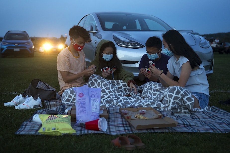 caption: From left, friends Nile, Julia, Ben and Catherine play UNO while waiting for Men In Black to begin on Tuesday, August 18, 2020, at the drive-in theater at Marymoor Park in Redmond. 