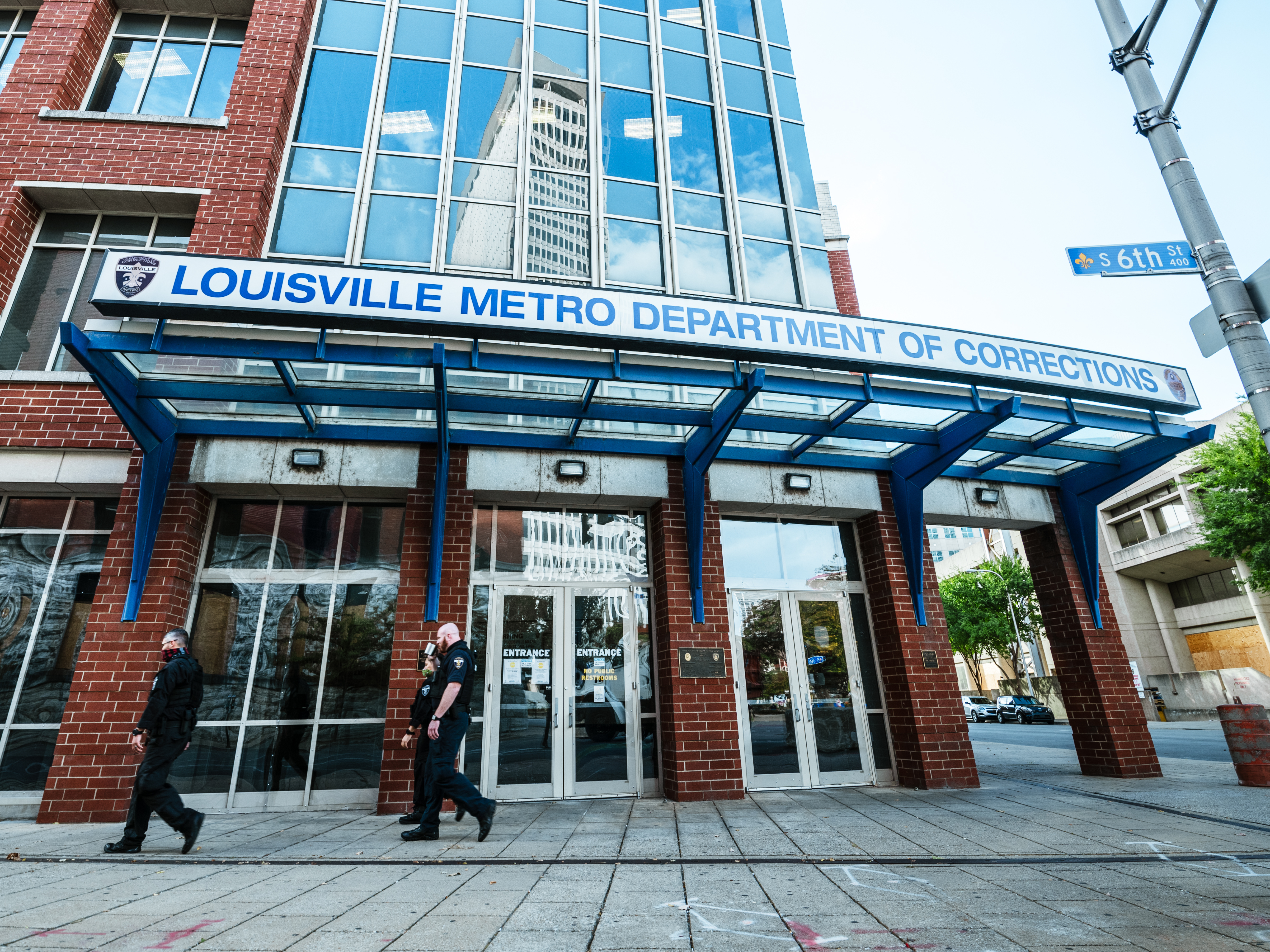 caption: The Jefferson County Circuit Court has released audio recordings of the grand jury proceedings in the Breonna Taylor case. Here, a group of police officers walk by the Louisville Metro Department of Corrections, which sits adjacent to Jefferson Square Park, which has been the epicenter for Black Lives Matter protests that seek justice for Taylor.