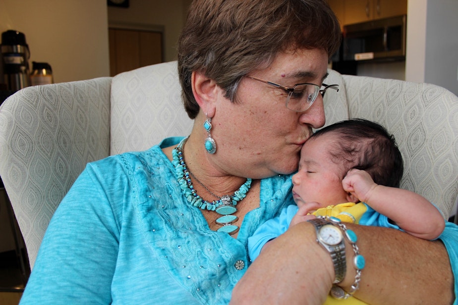 caption: Cindy McIntyre kisses her 1-month-old granddaughter Sophie Lin. She wrote Sophie Lin a letter, telling her that in the 1960s and 70s, they wondered if they should bring kids into the world. And yet out of that era came good, she says.