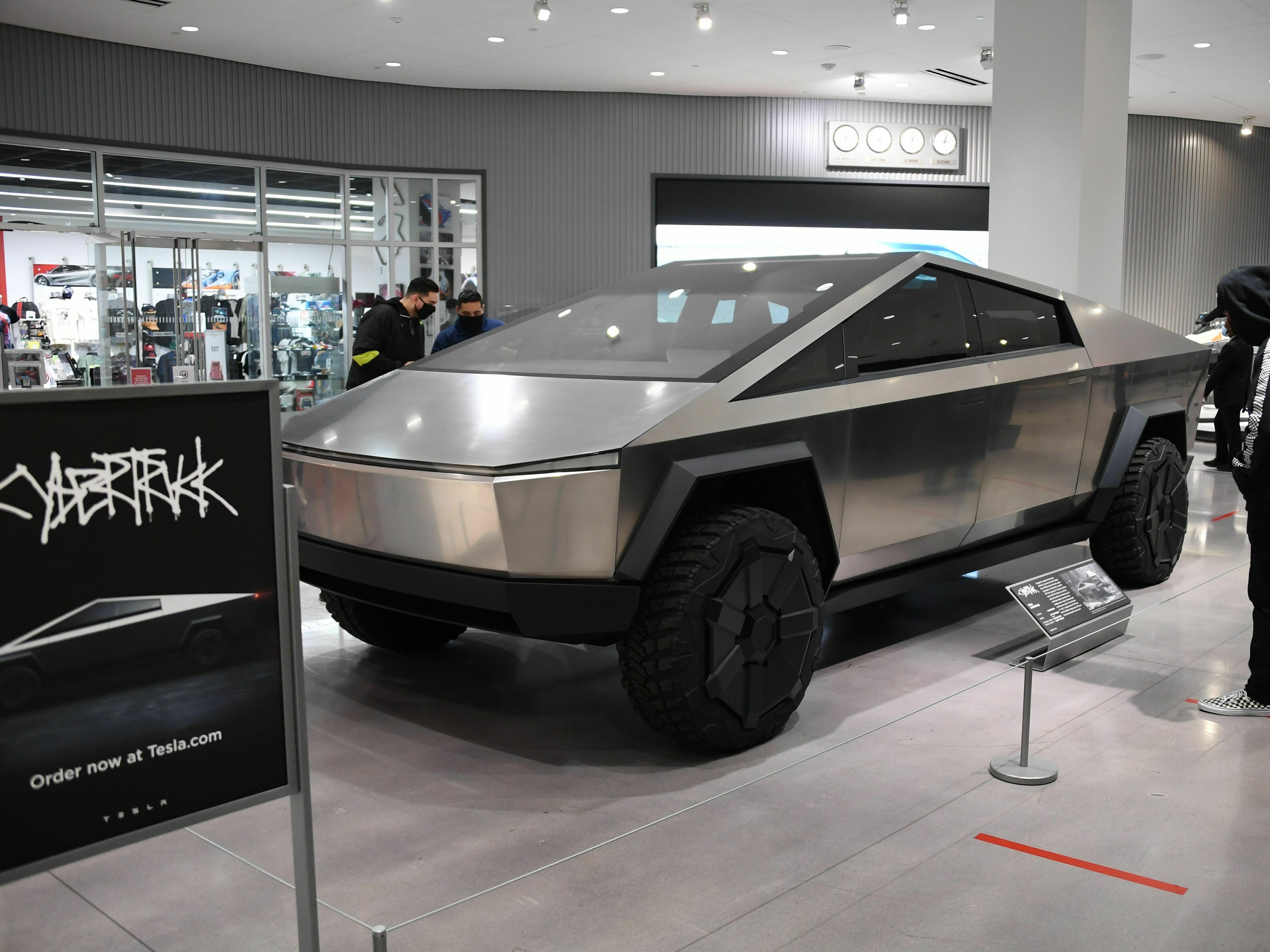 caption: Visitors wearing face coverings view the Telsa Cybertruck at the Petersen Automotive Museum in Los Angeles in July 2020.