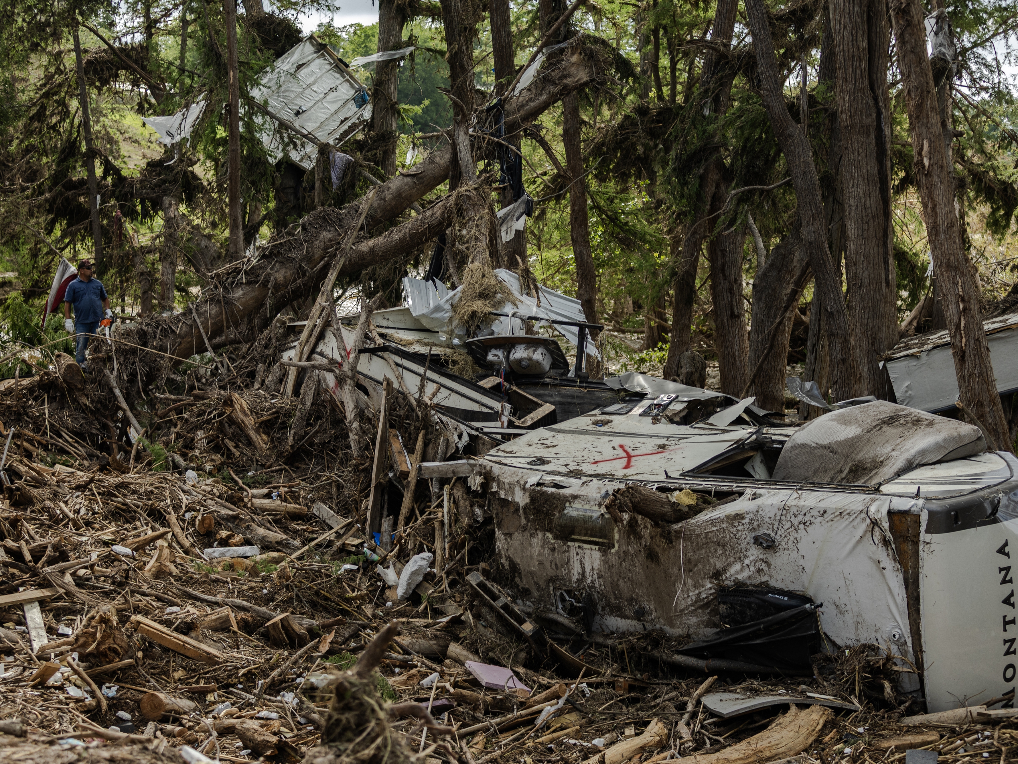 caption: Search and recovery crews remove debris from the bank of the Guadalupe River on July 9 in Center Point, Texas, after deadly flash floods. Most calls made between July 6 and July 9 to FEMA call centers went unanswered, according to call logs kept by the agency.