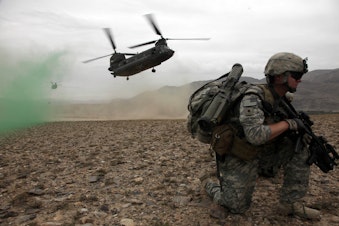 caption: U.S. Army Spc. Kevin Welsh provides security before boarding a CH-47 Chinook helicopter after completing a mission in Chak valley in the Wardak province of Afghanistan on Aug. 3, 2010. 