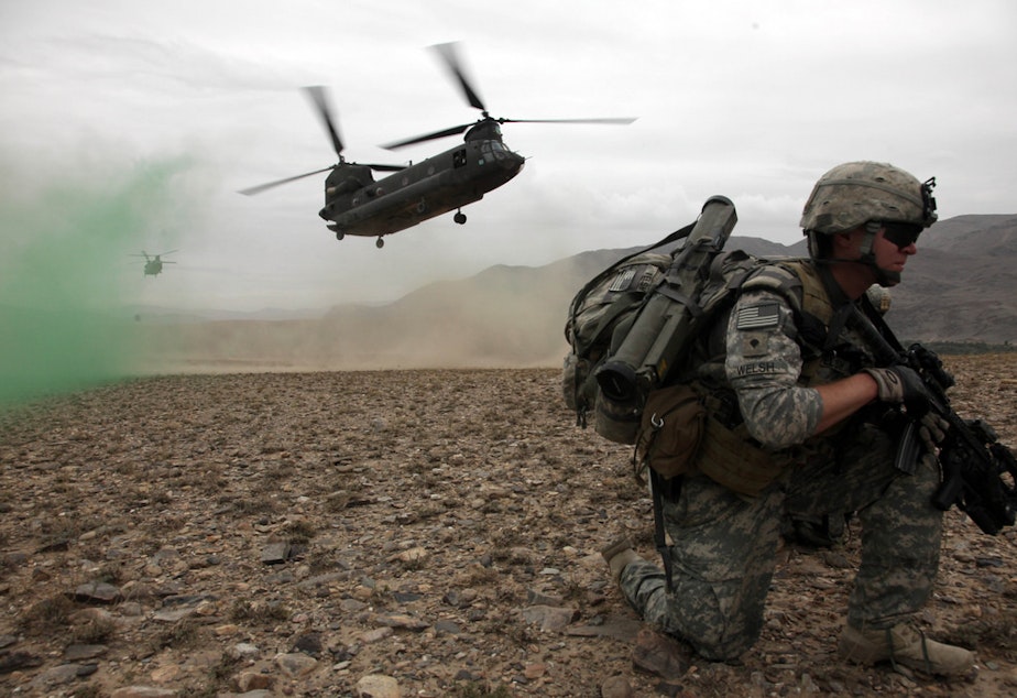 caption: U.S. Army Spc. Kevin Welsh provides security before boarding a CH-47 Chinook helicopter after completing a mission in Chak valley in the Wardak province of Afghanistan on Aug. 3, 2010.