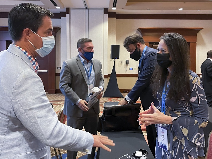 caption: Jen Easterly, director of the Department of Homeland Security's Cybersecurity and Infrastructure Security Agency, speaks with Ohio Secretary of State Frank LaRose, left, during the summer meeting of the National Association of Secretaries of State.