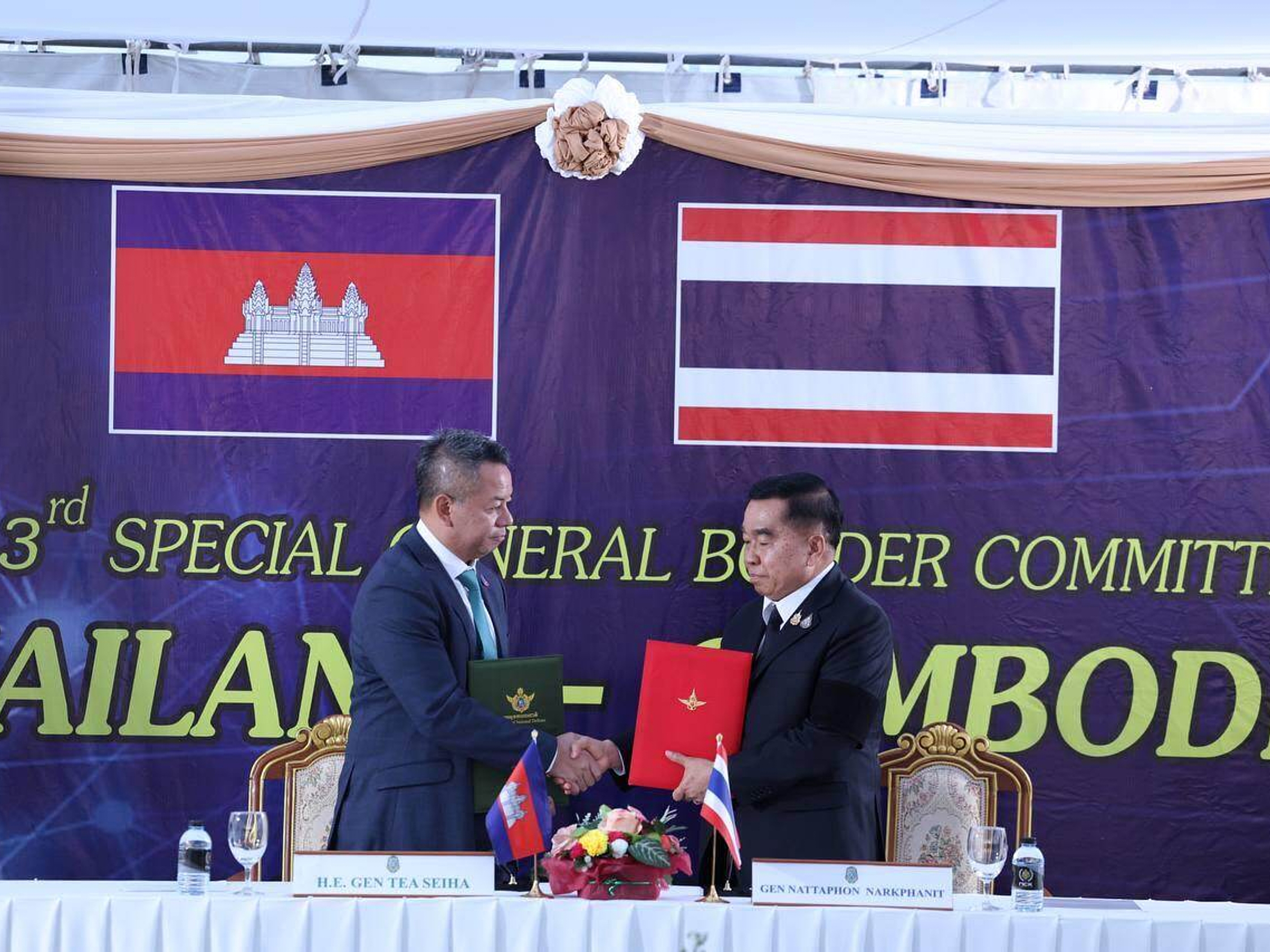 caption: In this photo released by Agence Kampuchea Press (AKP), Cambodian Defense Minister Tea Seiha, left, stands with Thai Defense Minister Natthaphon Narkphanit, right, at the General Border Committee Meeting in Chanthaburi Province, Thailand Saturday, Dec. 27, 2025.