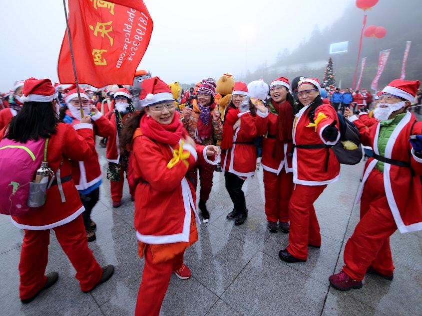 caption: People dressed as Santa Claus compete in a run to mark Christmas at Xiannu Mountain in Chongqing, China. Even though only about 5 percent of the population is Christian, many people celebrate during the holiday.