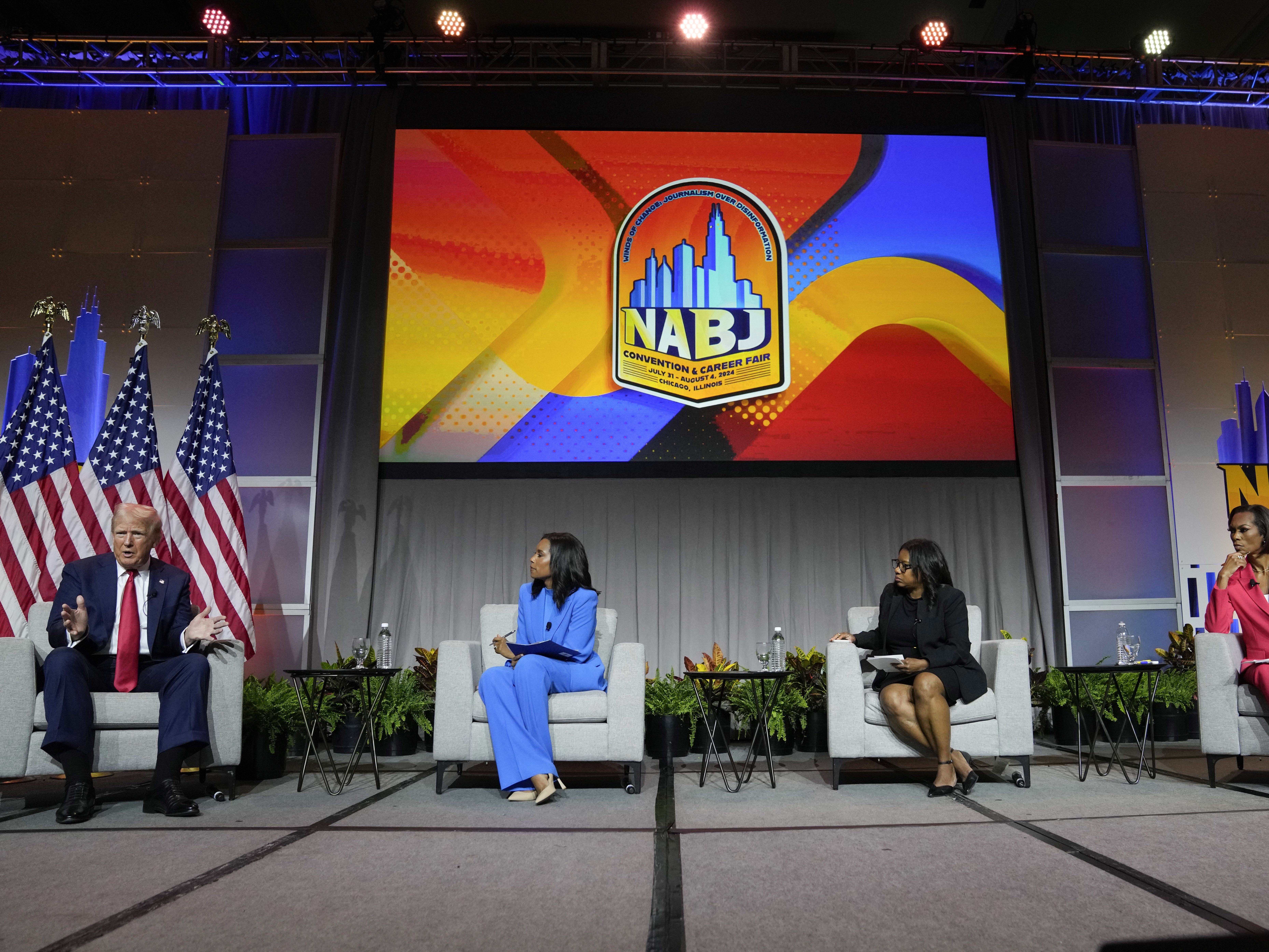 caption: Former President Donald Trump appears on a panel at NABJ on Wednesday in Chicago. From left, ABC's Rachel Scott, Semafor's Kadia Goba and FOX News' Harris Faulkner moderated the event.