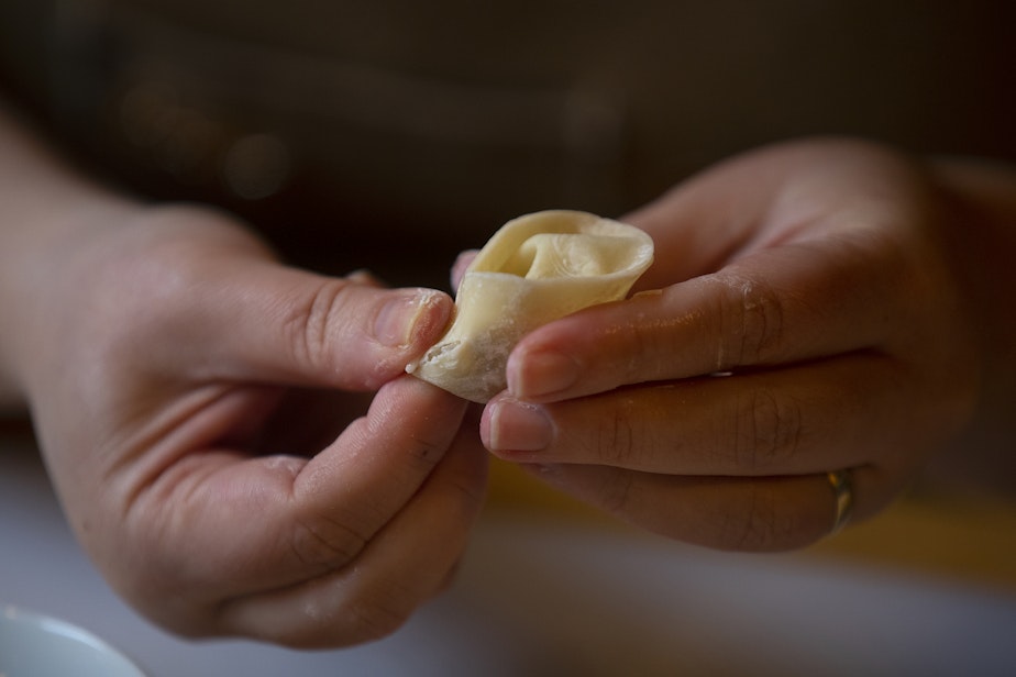 caption: Sara Upshaw, owner of OHSUN Banchan Deli & Cafe, folds two edges of the dumpling together, on Tuesday, February 6, 2024, at the restaurant in Seattle’s Pioneer Square neighborhood. 