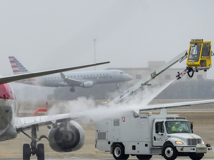 caption: An American Airlines aircraft undergoes deicing procedures on Monday, Jan. 30, 2023, at Dallas/Fort Worth International Airport in Texas.
