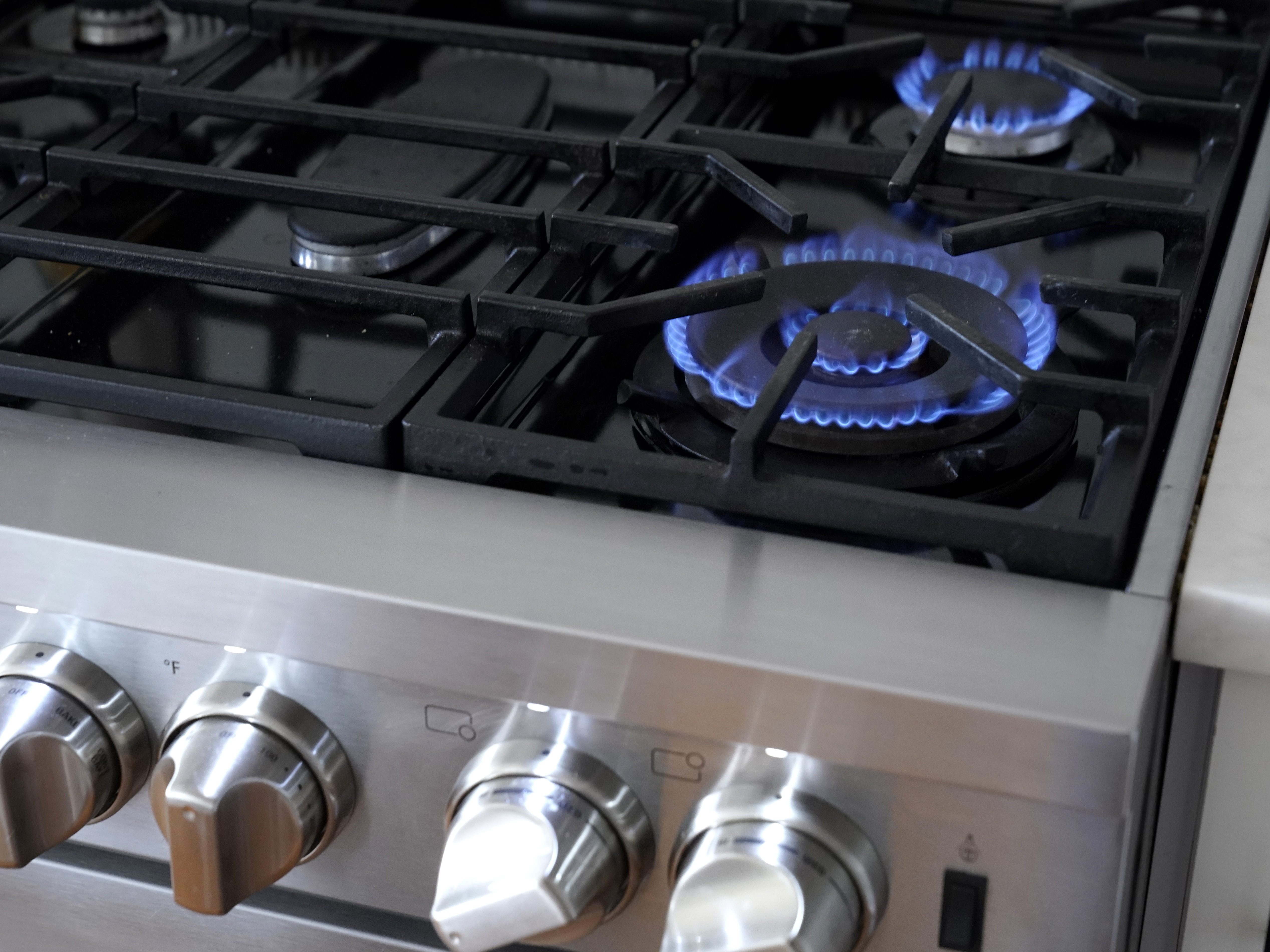 caption: The blue flames of a natural gas stove emit harmful pollutants, such as nitrogen dioxide. Consumer and environmental watchdog groups want health warning labels on new gas stoves to let buyers know of the risks.