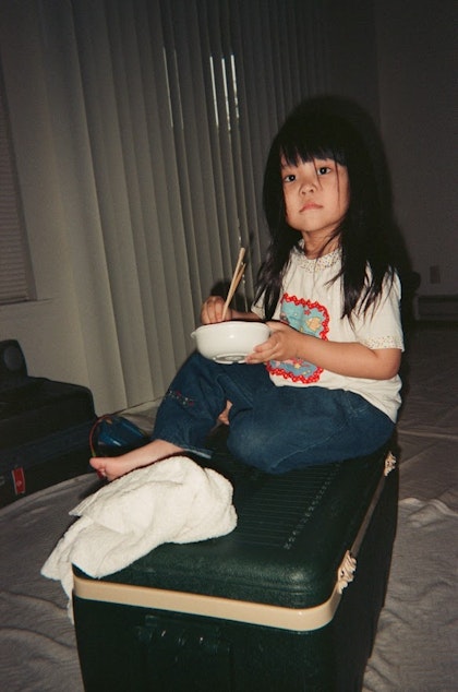 caption: Melissa Takai as a kindergartener eating a meal in her home. Takai says she remembers her mom spending a lot of time making her lunch every day, even though her mom was working multiple jobs to make ends meet.