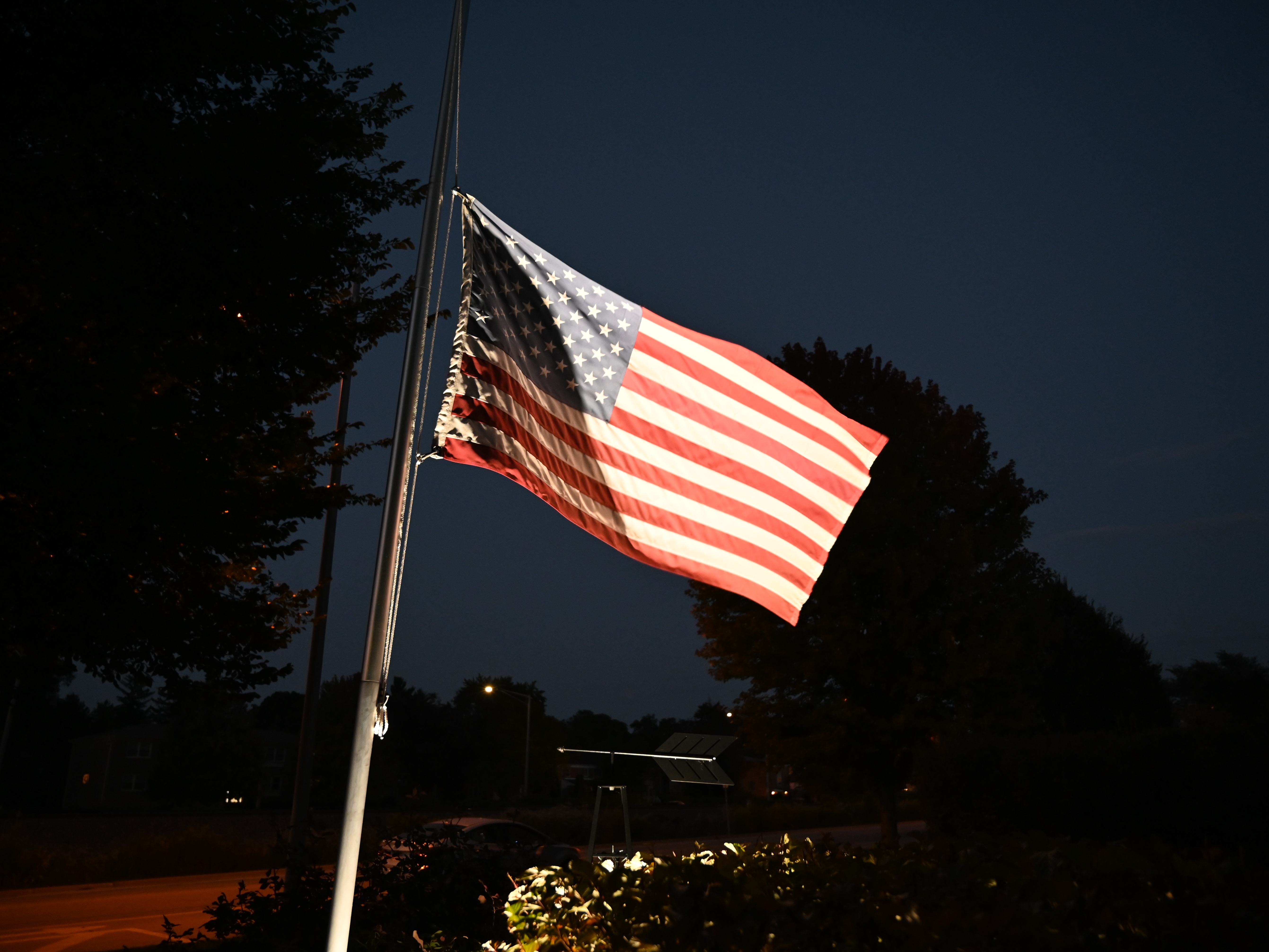 caption: U.S. flags fly at half staff following the assassination of conservative commentator Charlie Kirk at Utah Valley University on Sept. 10 in Chicago.