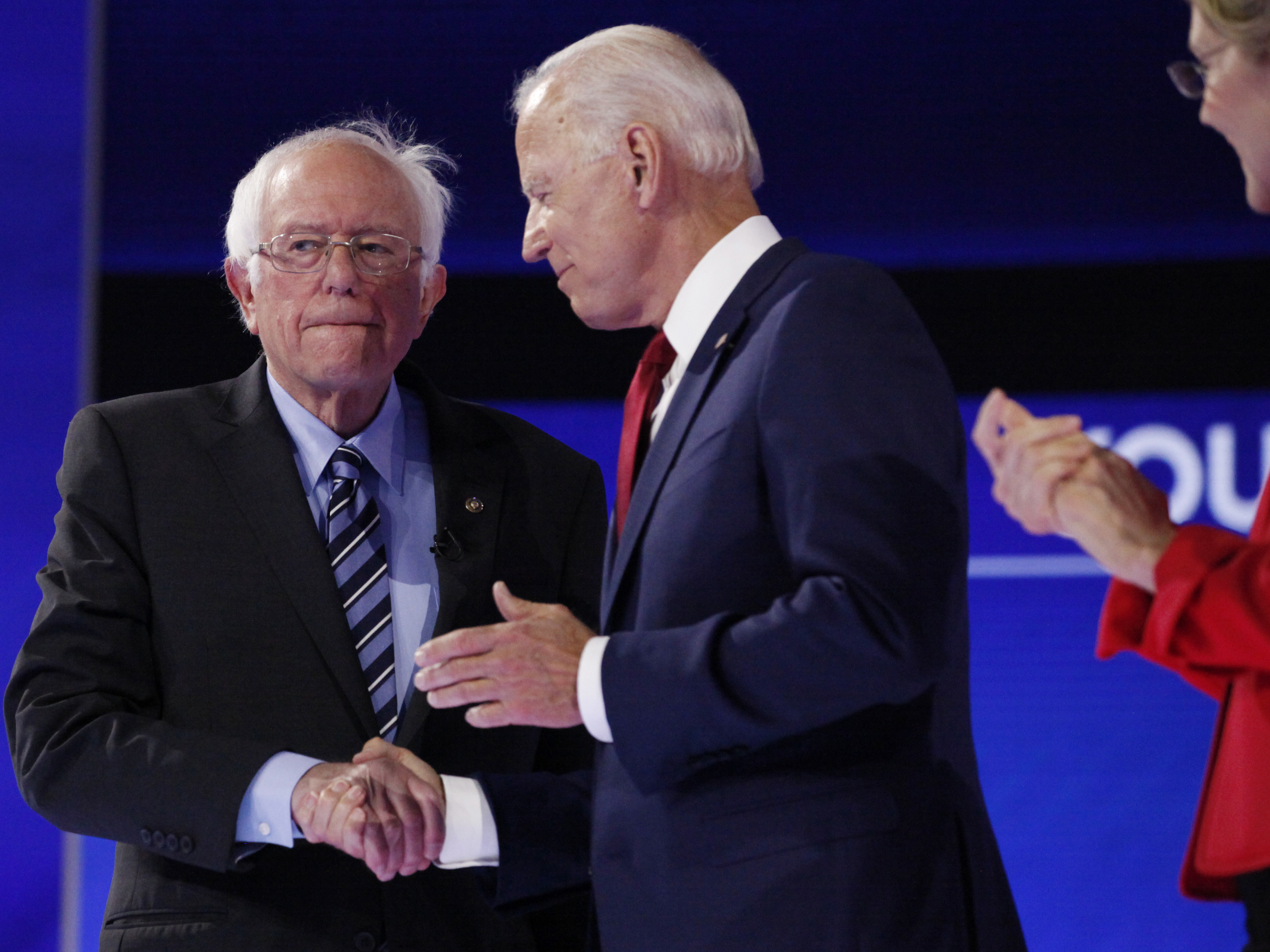 caption: Sen. Bernie Sanders shakes hands with former Vice President Joe Biden Thursday.