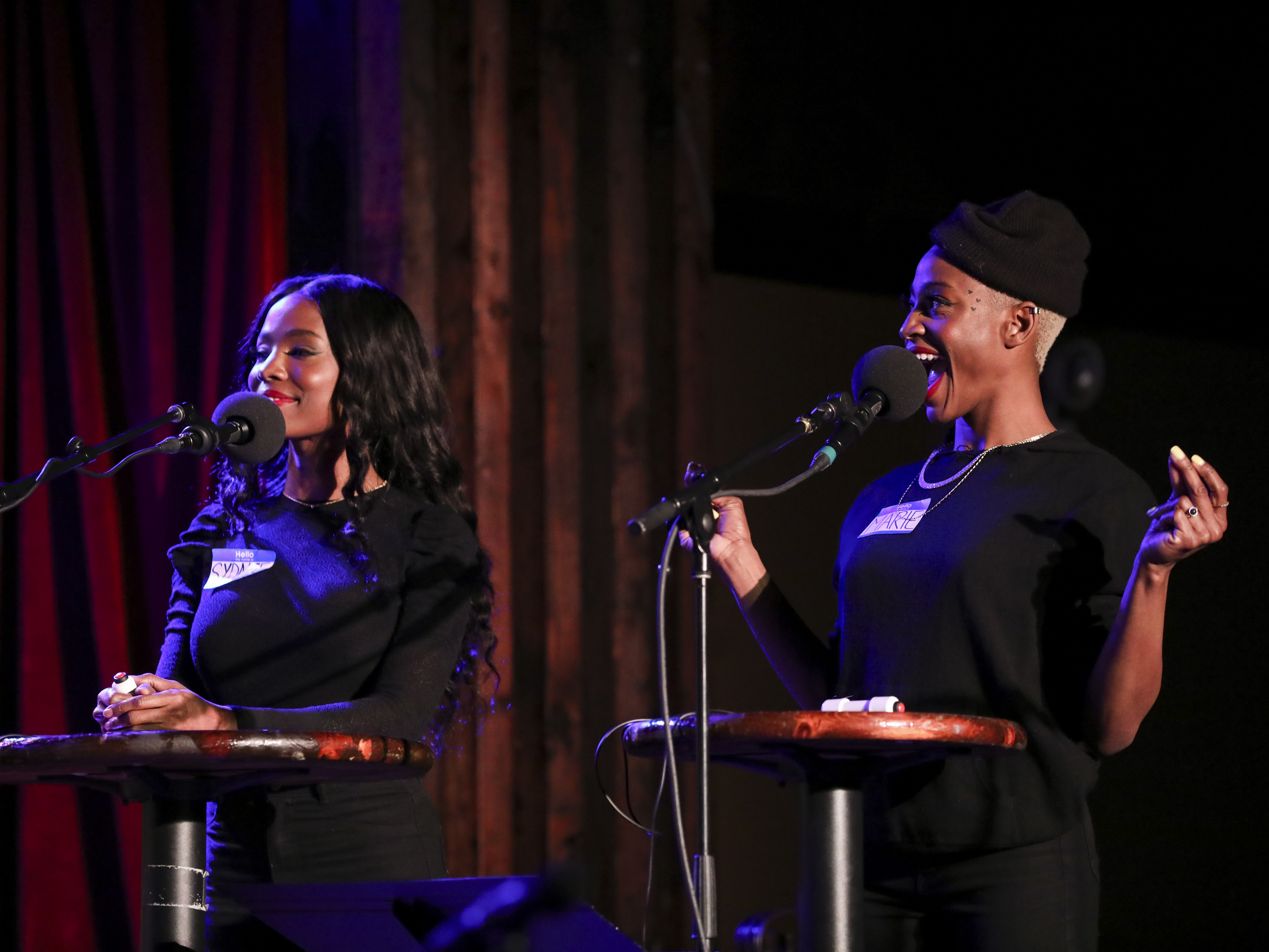 caption: Podcast hosts Sydnee Washington and Marie Faustin play games on <em>Ask Me Another</em> as part of the Brooklyn Podcast Festival at the Bell House in New York.