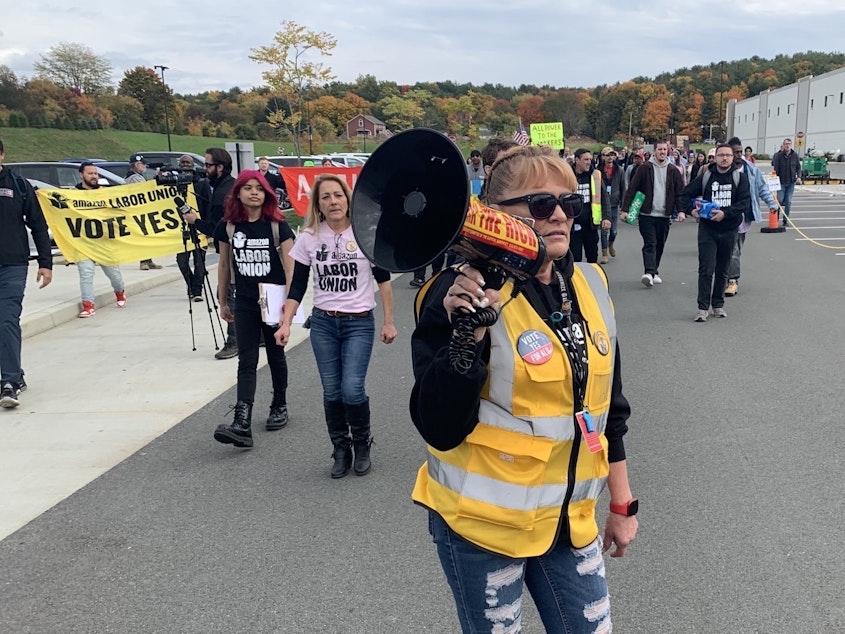caption: Organizer Heather Goodall, who works at Amazon's warehouse near Albany, N.Y., leads supporters of the Amazon Labor Union in a march on Oct. 10.