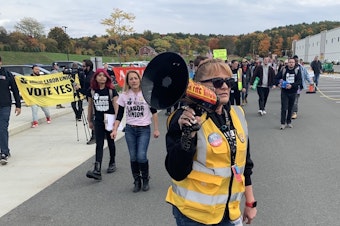 caption: Organizer Heather Goodall, who works at Amazon's warehouse near Albany, N.Y., leads supporters of the Amazon Labor Union in a march on Oct. 10.