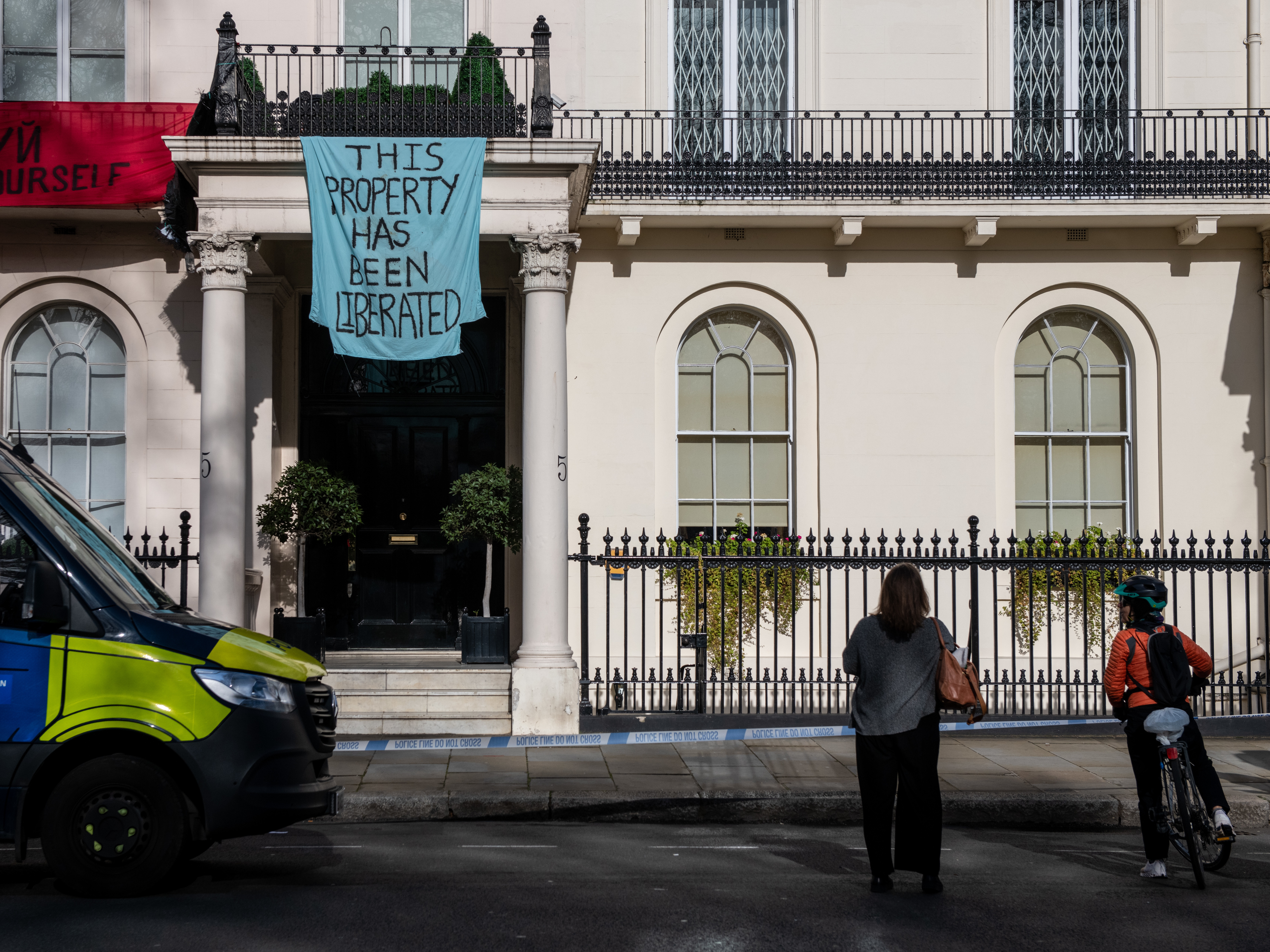 caption: Protesters occupy a building reportedly belonging to Russian oligarch Oleg Deripaska on Monday in London.