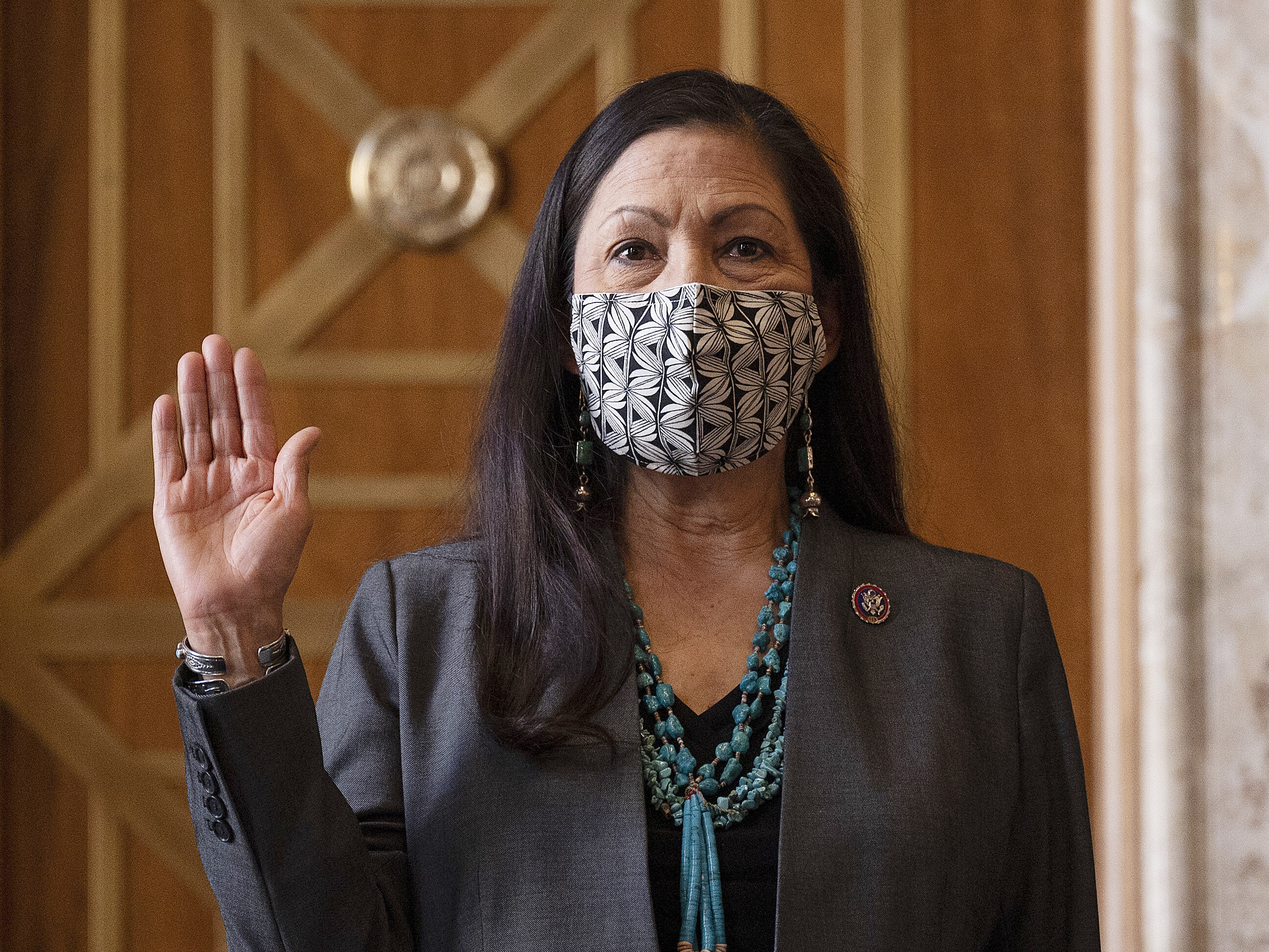 caption: Rep. Deb Haaland, D-N.M., is sworn in before her Senate confirmation hearing to be interior secretary last month. Her confirmation makes her the United States' first Native American Cabinet secretary.