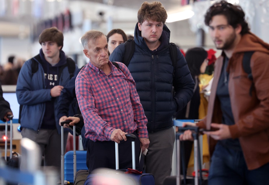 caption: Travelers arrive for flights at O'Hare International Airport in Chicago on Dec. 16.