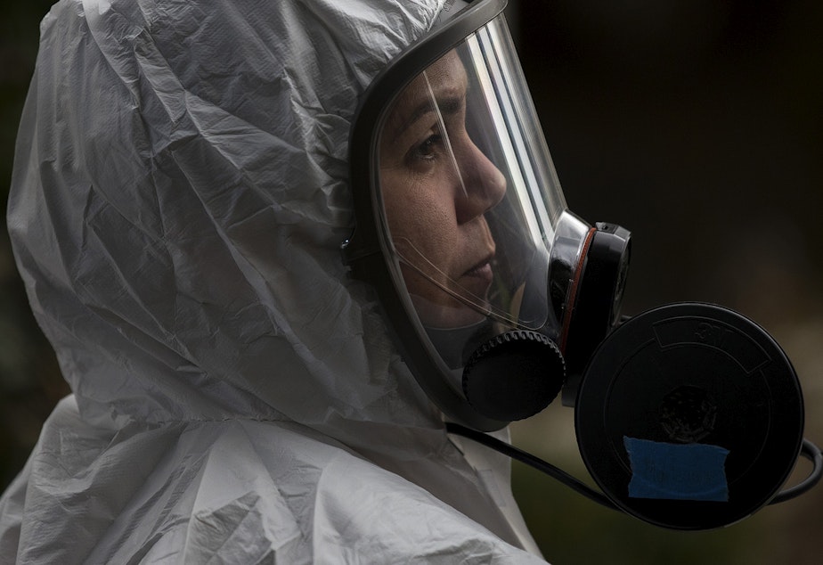 caption: A member of a Servpro cleaning crew stands in line before entering the Life Care Center of Kirkland, the long-term care facility at the epicenter of the coronavirus outbreak in Washington state, on Wednesday, March 11, 2020, in Kirkland.