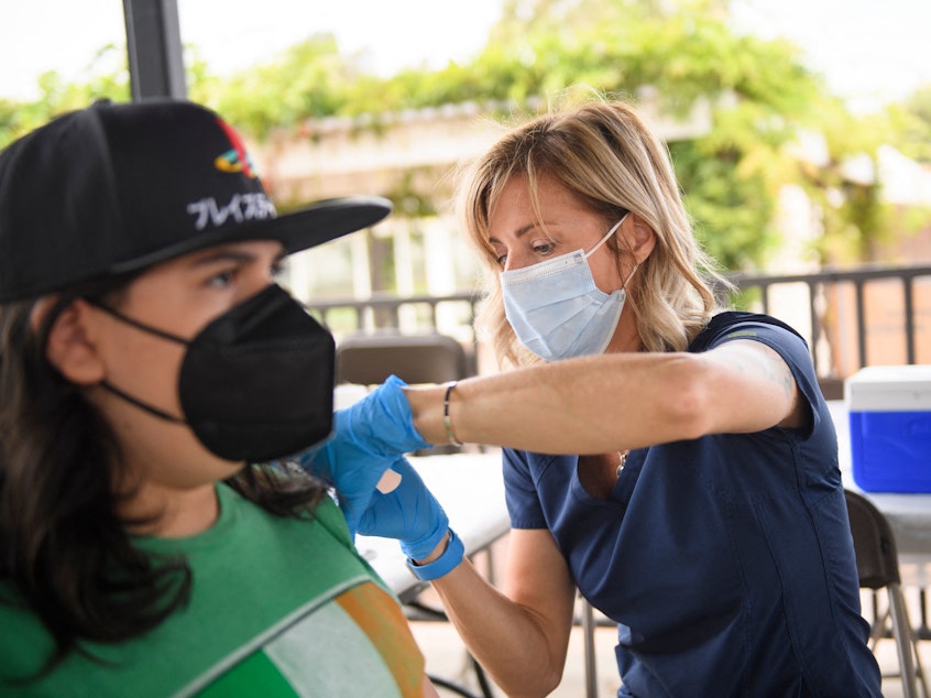 caption: A nurse administers a dose of the Pfizer Covid-19 vaccine during a City of Long Beach Public Health Covid-19 mobile vaccination clinic at the California State University Long Beach campus.