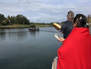 caption: <p>Grand Ronde Tribal Chairwoman Cheryle Kennedy and Tribal Secretary Jon A. George watch as tribal employees launch a boat to build a fishing platform at Willamette Falls.</p>