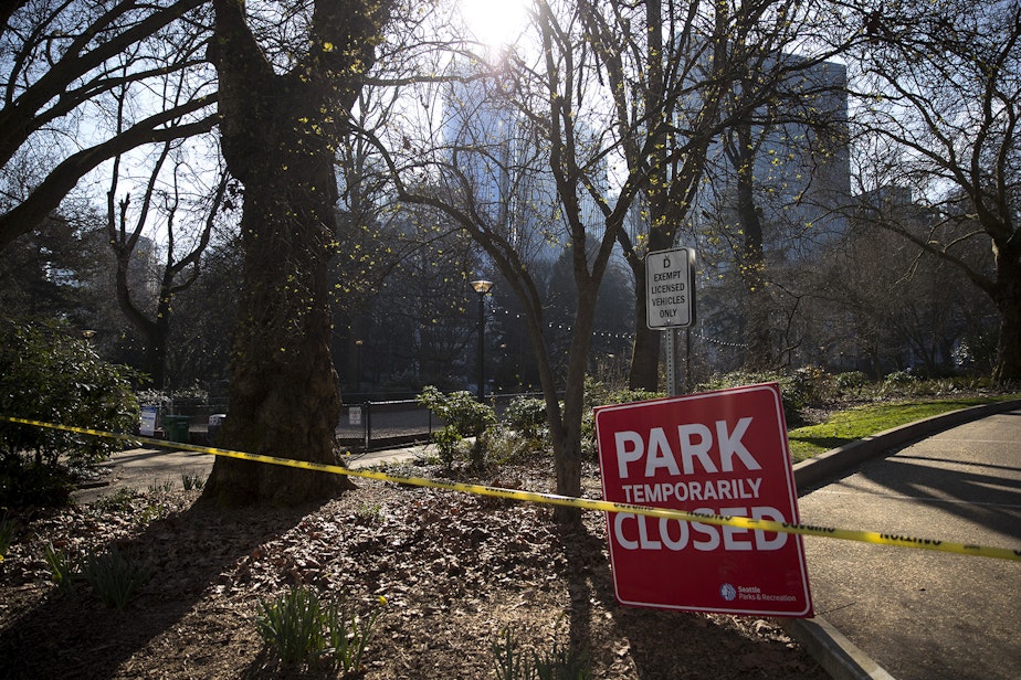 caption: A 'Park Temporarily Closed' sign is shown as Seattle police and Parks and Recreation sweep unhoused people from Denny Park on Wednesday, March 3, 2021, in Seattle.