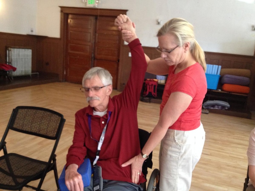 caption: Lan Remme, 67, works with his wife Laura at Adaptive Yoga in the Central District.