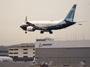 caption: A Boeing 737 MAX jet, piloted by Federal Aviation Administration (FAA) chief Steve Dickson, prepares to land at Boeing Field following a test flight on Wednesday.