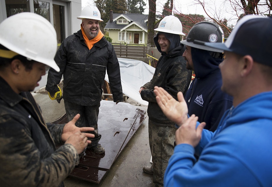 caption: From left, Anthony Banks, Zack Larson, Chris Chase, Devin Ottesen and James Kennemer laugh while working on a job site on Tuesday, January 9, 2018, on 38th Ave East in Seattle.
