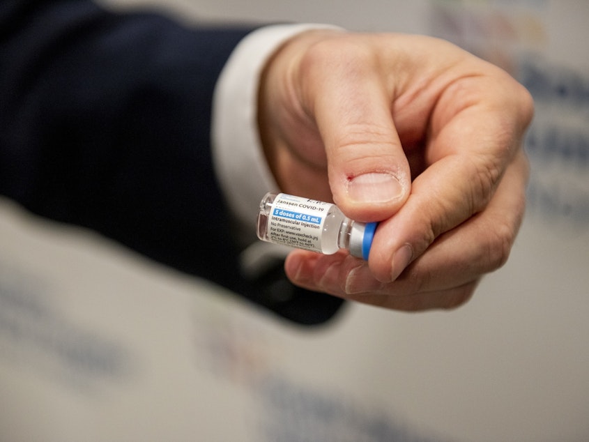 caption: A health care worker holds a vial of the Johnson & Johnson COVID-19 vaccine at South Shore University Hospital in Bay Shore, N.Y., on Wednesday.