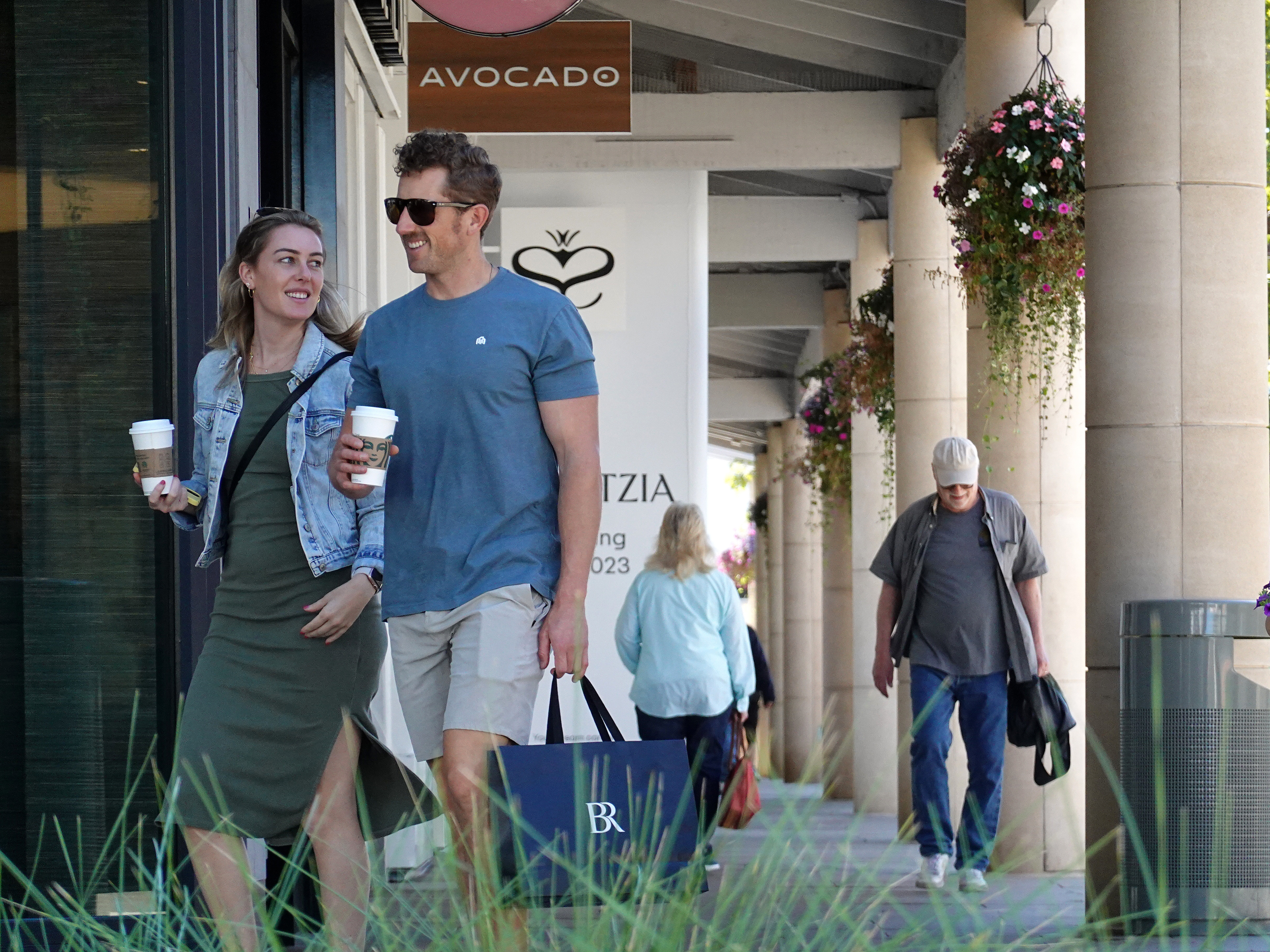 caption: A shopper carries a shopping bag while walking through an outdoor shopping center in Corte Madera, Calif., on Oct. 17. Strong consumer spending is helping to power the economy — but it may not last.