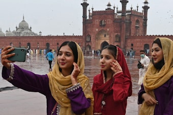 caption: Muslim devotees takes a selfie using their mobile phones after offering special prayers at the historic Badshahi Mosque in Lahore, Pakistan.