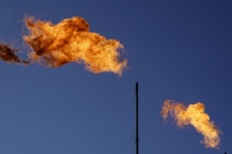caption: Flares burn off methane and other hydrocarbons at an oil and gas facility in Lenorah, Texas in 2021. New research shows drillers emit about three times as much climate-warming methane as official estimates.