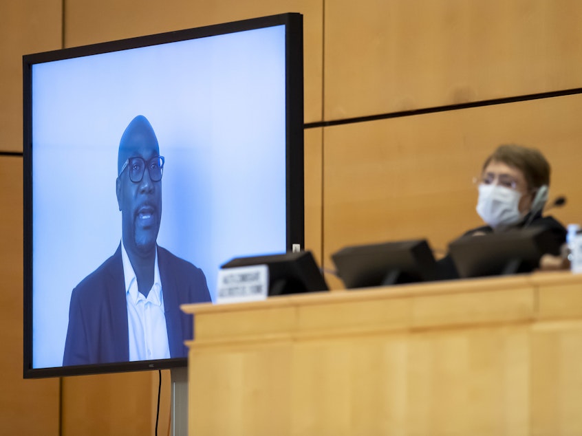 caption: Philonise Floyd speaks via video to the U.N. Human Rights Council in Geneva on Wednesday, weeks after the killing of his brother George incited widespread protests against police brutality. U.N. human rights chief Michelle Bachelet looks on behind her face mask.