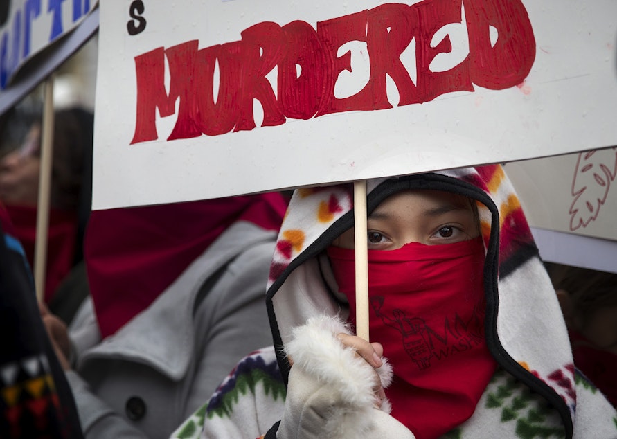 caption: Denae Shippentower, 11, of the Puyallup Tribe stands with other members of the Missing and Murdered Indigenous Women of Washington group before the start of the Women's March on Saturday, January 20, 2018, in Seattle.