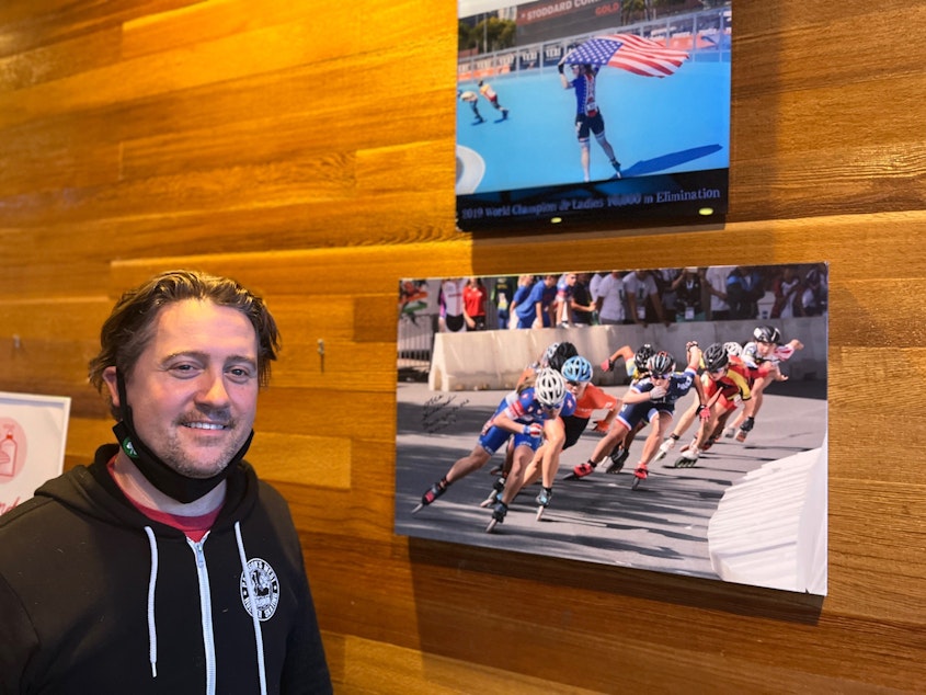 caption: Inline skating coach Darin Pattison proudly stands beside some of the many photos of one of his proteges, Olympic short track speedskater Corinne Stoddard of Federal Way, WA, at the Pattison West roller rink in Stoddard’s hometown.