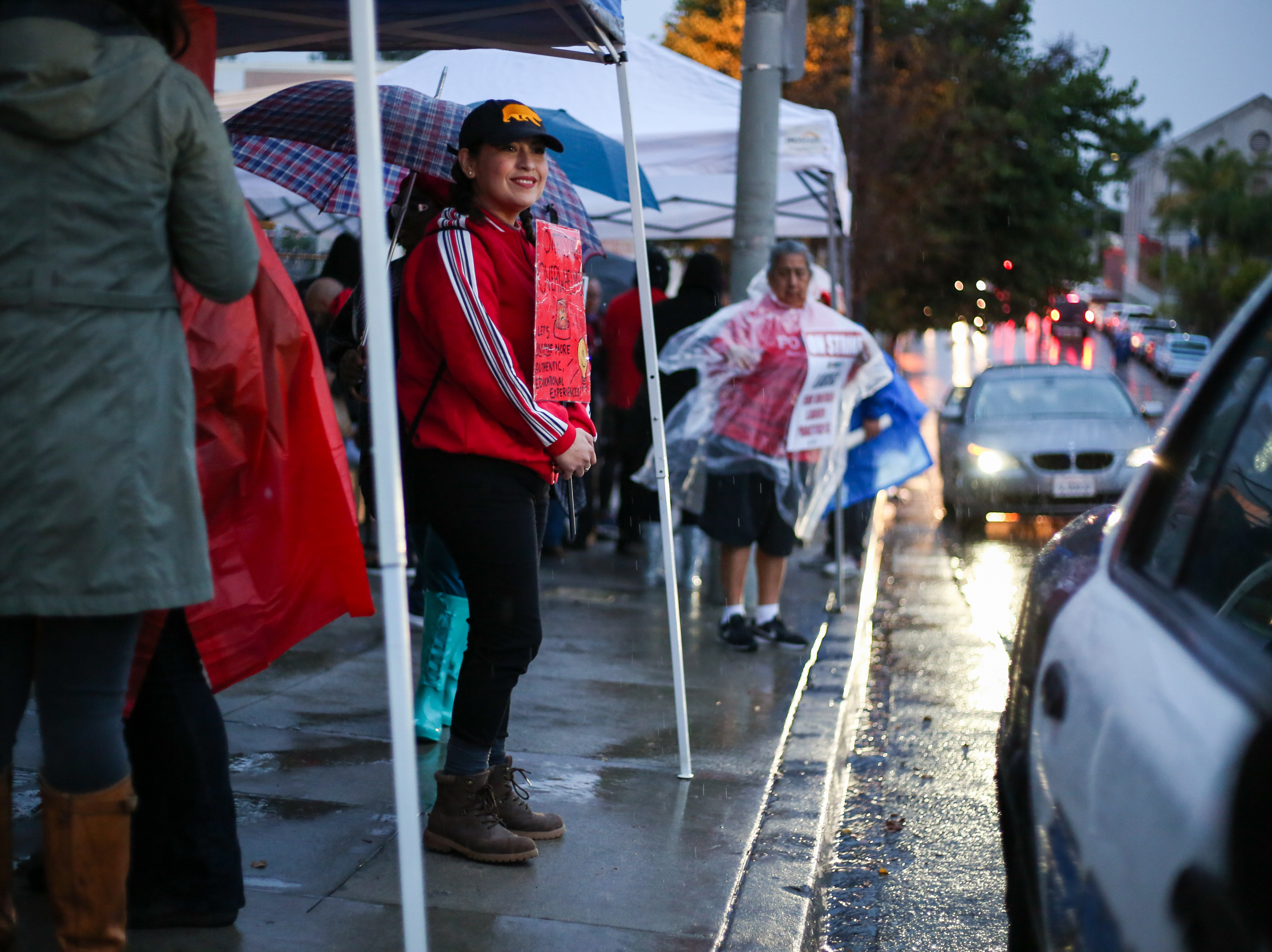 caption: A demonstrator outside Hollenbeck Middle School in Boyle Heights, Los Angeles, flashes a friendly smile to passersby.