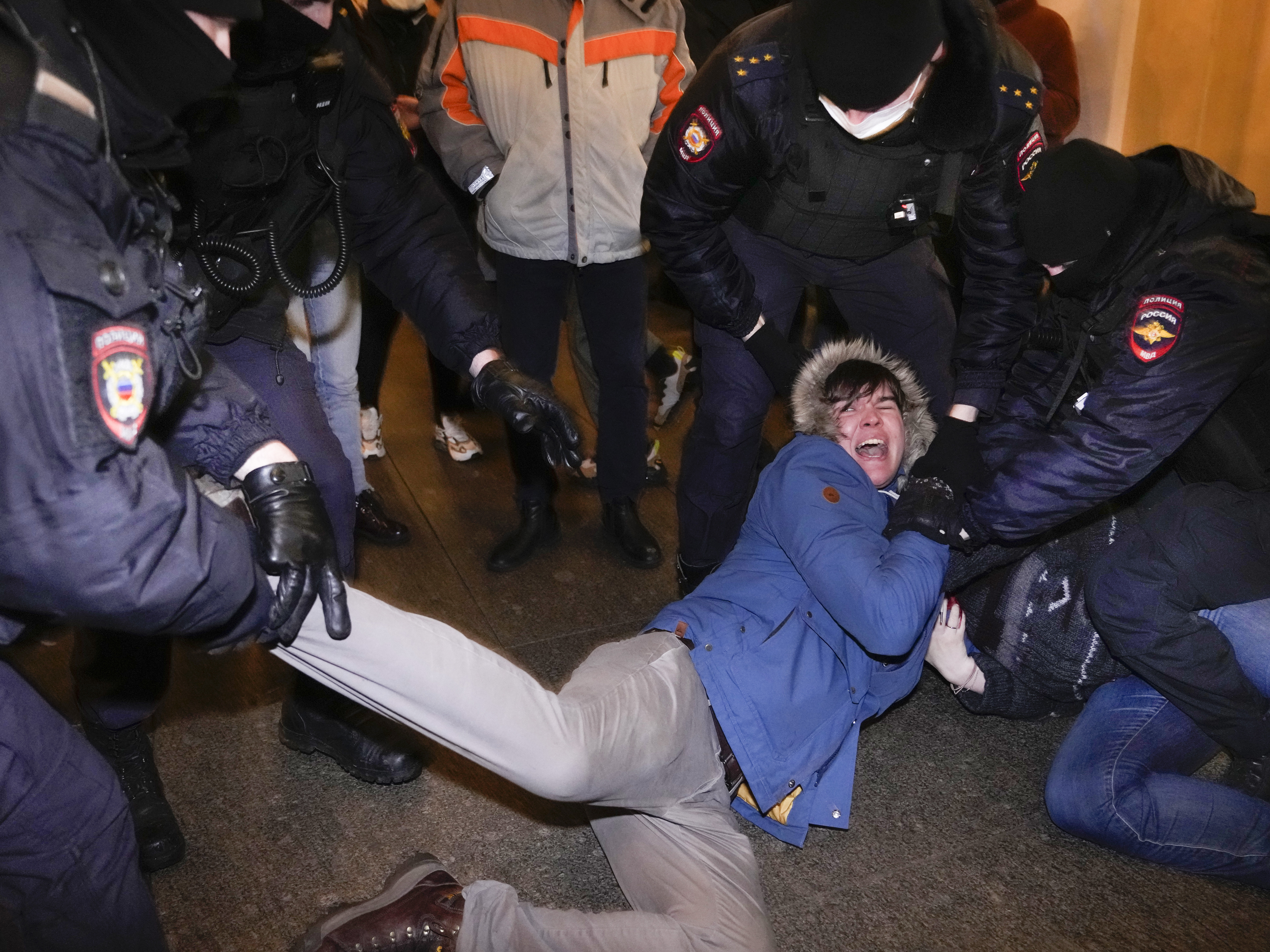 caption: Police officers detain demonstrators in St. Petersburg, Russia, Thursday. Hundreds of people gathered in Moscow and St.Petersburg to protest against Russia's attack on Ukraine.