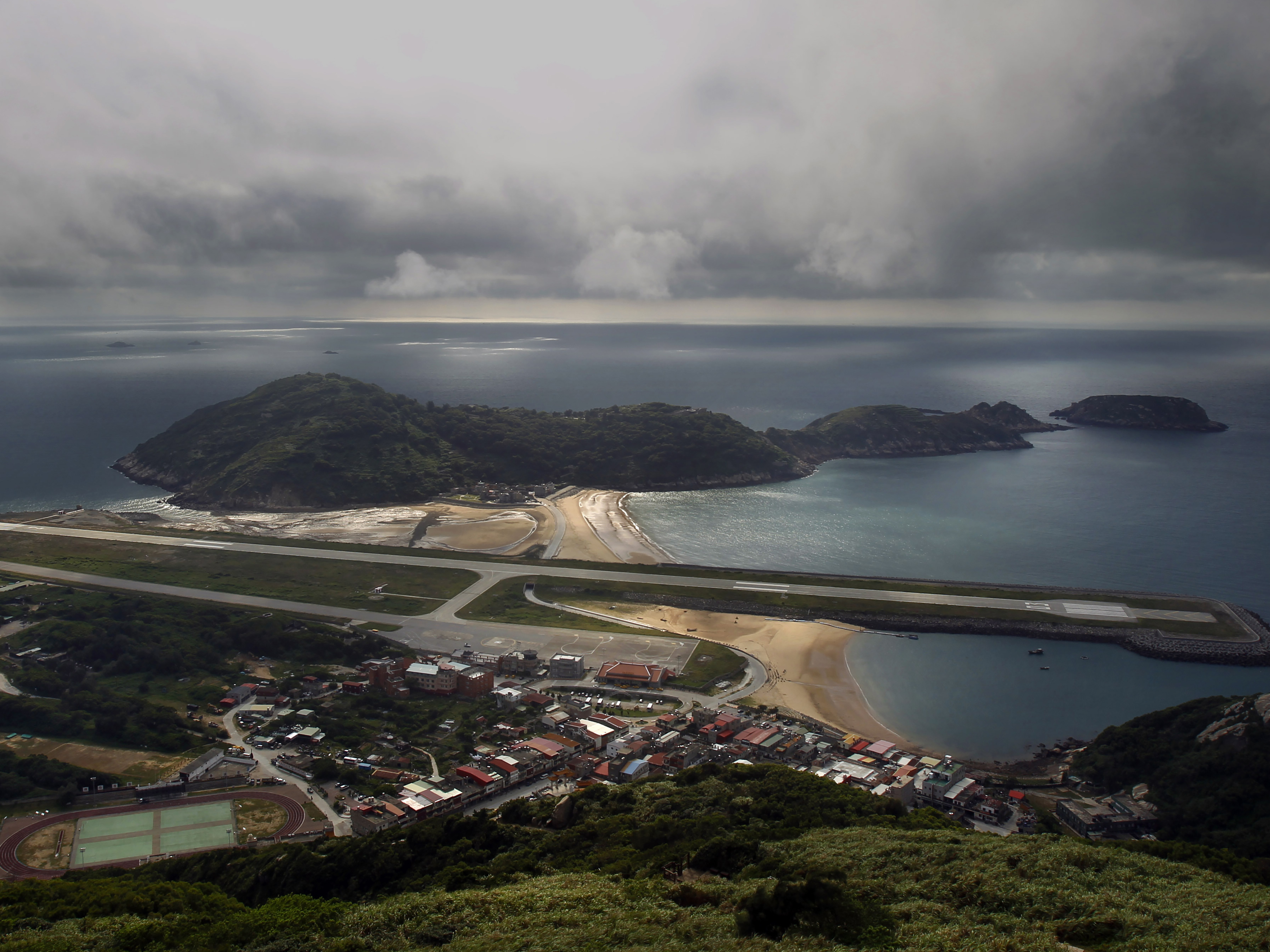 caption: A view from the 220-meter (670 feet) summit of Mt. Bi looks down on the airport's single runway jutting out into into the sea on Beigan in the Matsu island group, off northern Taiwan, Aug. 22, 2012.