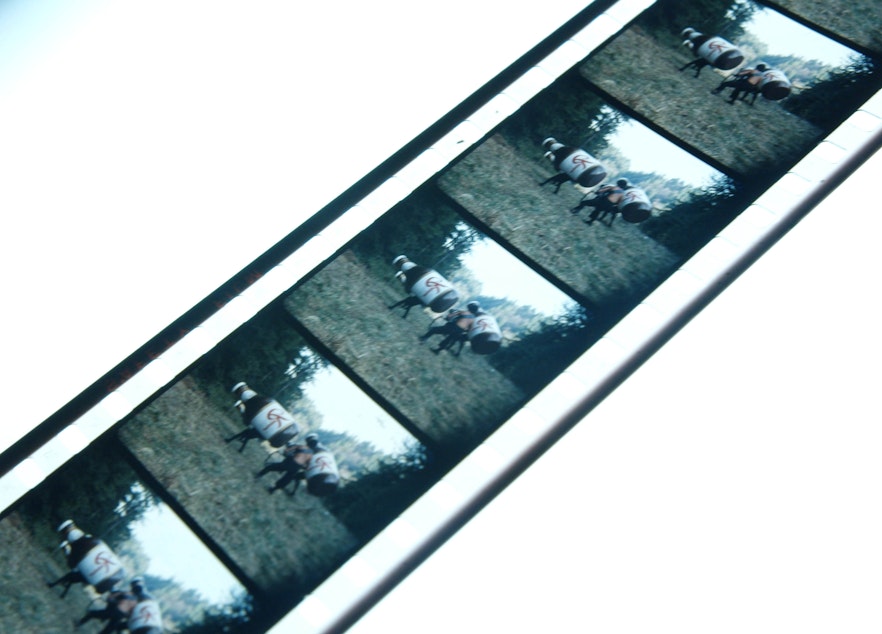 caption: A film strip from the shooting of a Rainier Beer advertisement featuring the iconic beer with legs. The film was digitized for the documentary Rainier: A Beer Odyssey. 