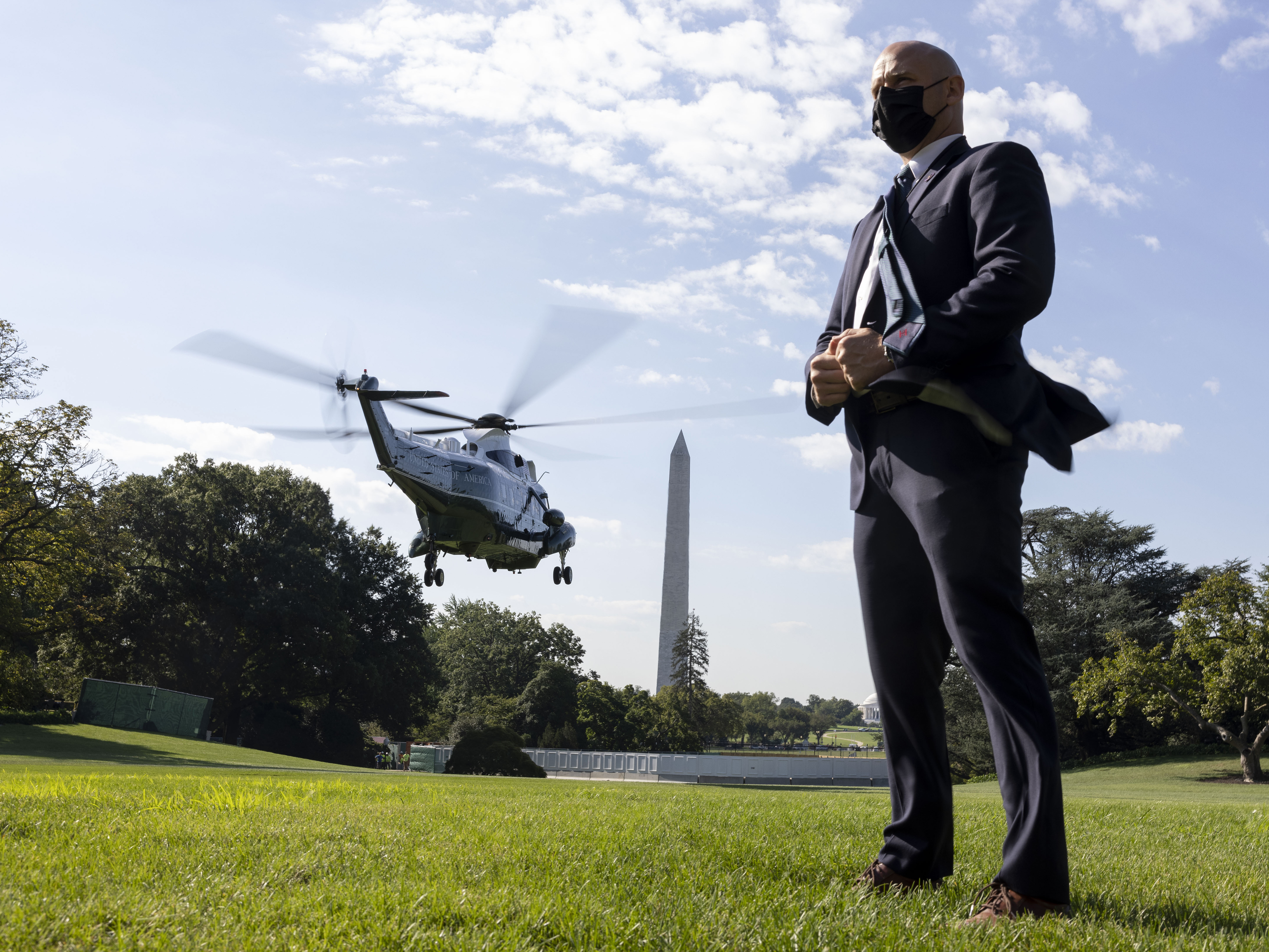 caption: A U.S. Secret Service agent stands by as Marine One departs with President Biden aboard as he departs the White House in September 2021.